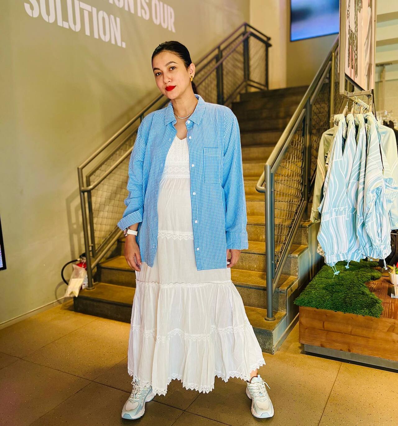 Gauahar’s maternity look is effortlessly chic with a flowy white maxi dress, layered with light blue checkered shirt exuding cool and comfy vibe. 